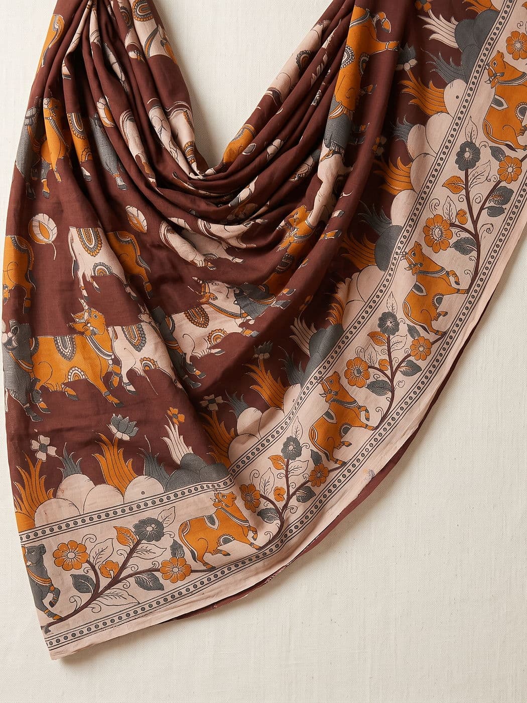 Nandini brown Kalamkari dupatta draped loosely, the cow-and-vine border running the full length
